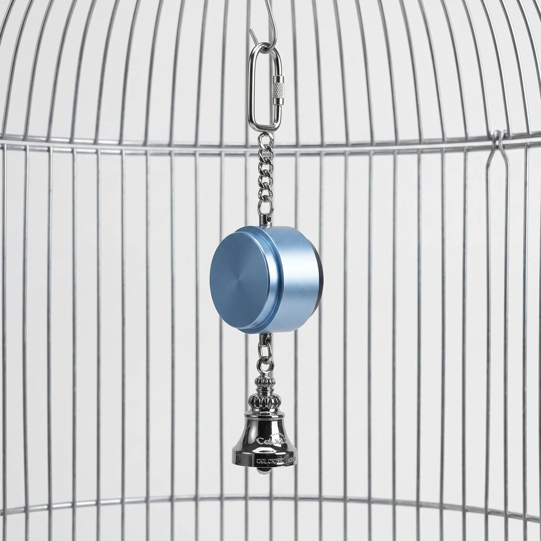Blue cylindrical toy hanging from a cage top by a locking carabiner and chain, with a silver bell below. 1