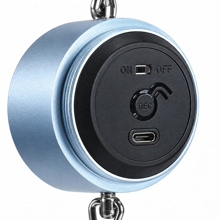 Close-up of the open back of the blue cylinder showing the on/off slider, record button and USB-C charging port. 3