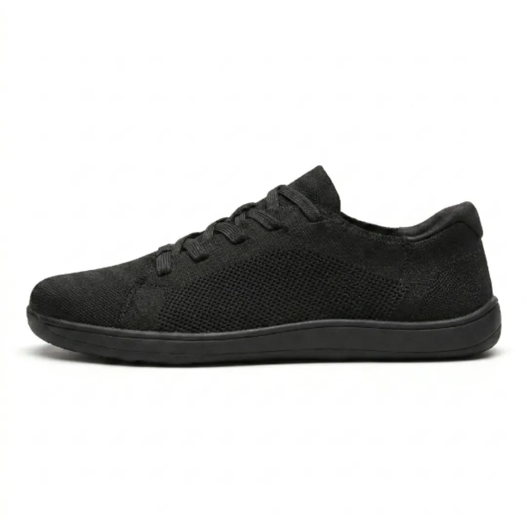Side view of an all-black knit lace-up sneaker with a mesh side panel and a thin flat sole.