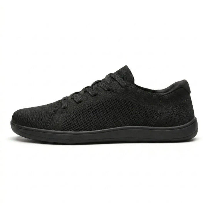 Side view of an all-black knit lace-up sneaker with a mesh side panel and a thin flat sole.