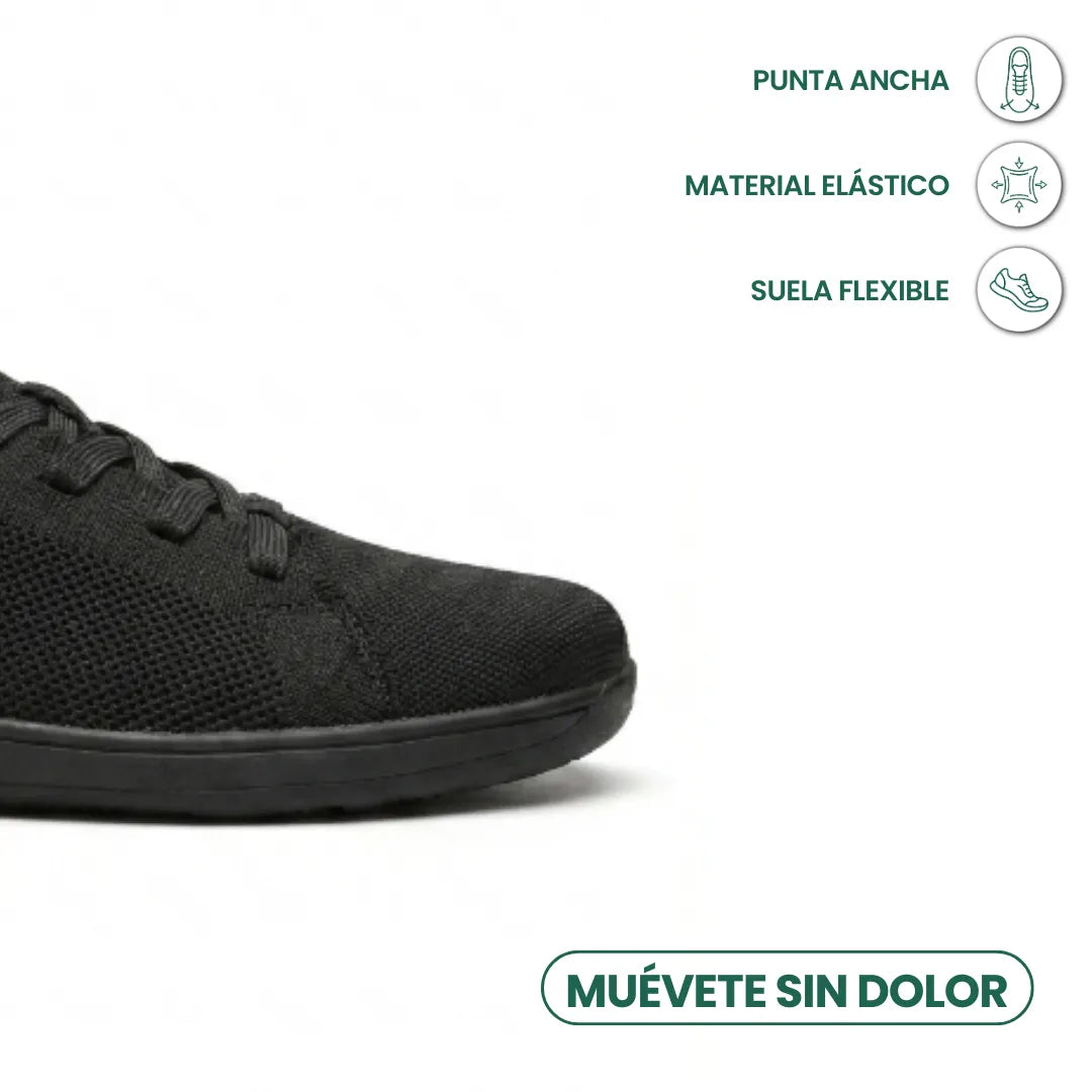 Close-up detail of the wide rounded toe of a black sneaker with callouts for stretchy material and flexible sole.