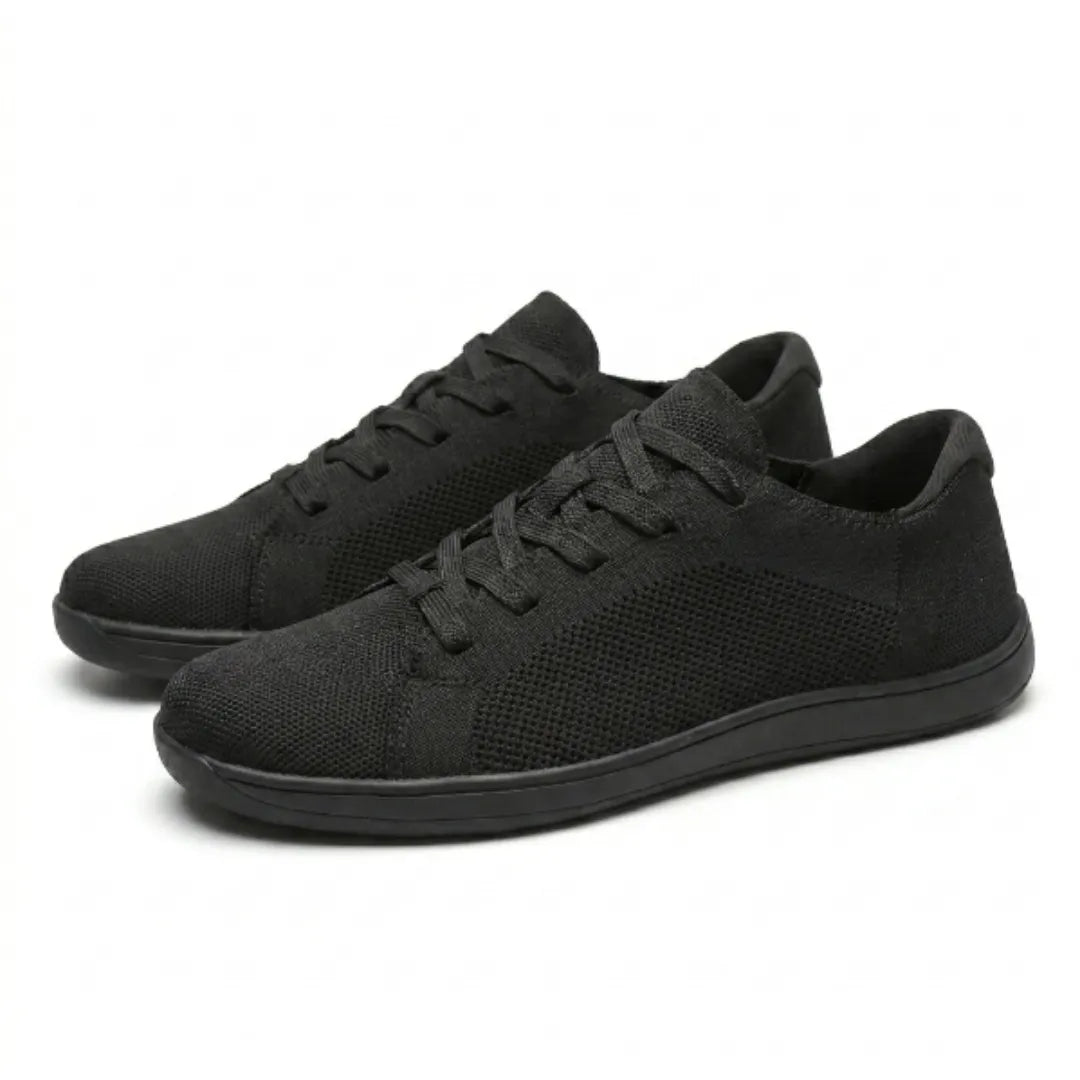 Pair of black knit sneakers shown at an angle, one in front of the other, with black laces and sole.