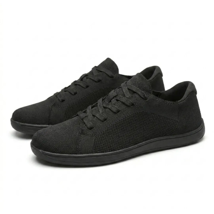Pair of black knit sneakers shown at an angle, one in front of the other, with black laces and sole.
