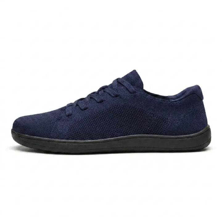 Side view of a navy blue knit lace-up sneaker with a mesh side panel and a flat black sole.