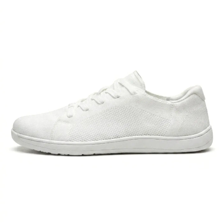 Side view of a single all-white knit sneaker with white sole, mesh panel and white laces on a white background. 37