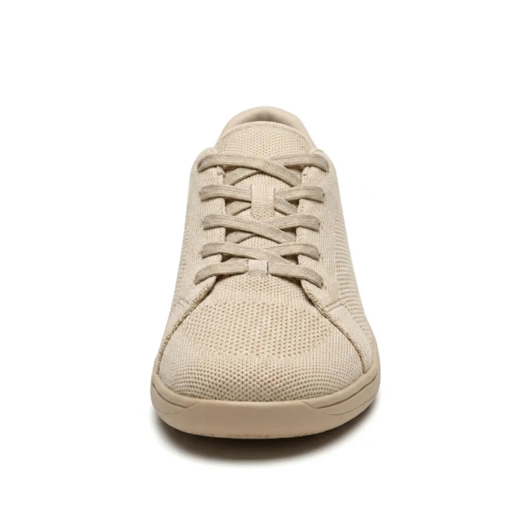 Front view of a beige knit sneaker showing the criss-cross laces, rounded toe cap and flat sole.