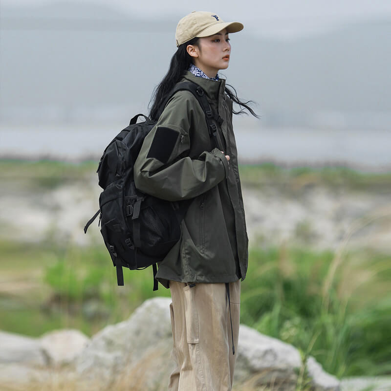 Olive green jacket, side view with a black backpack.