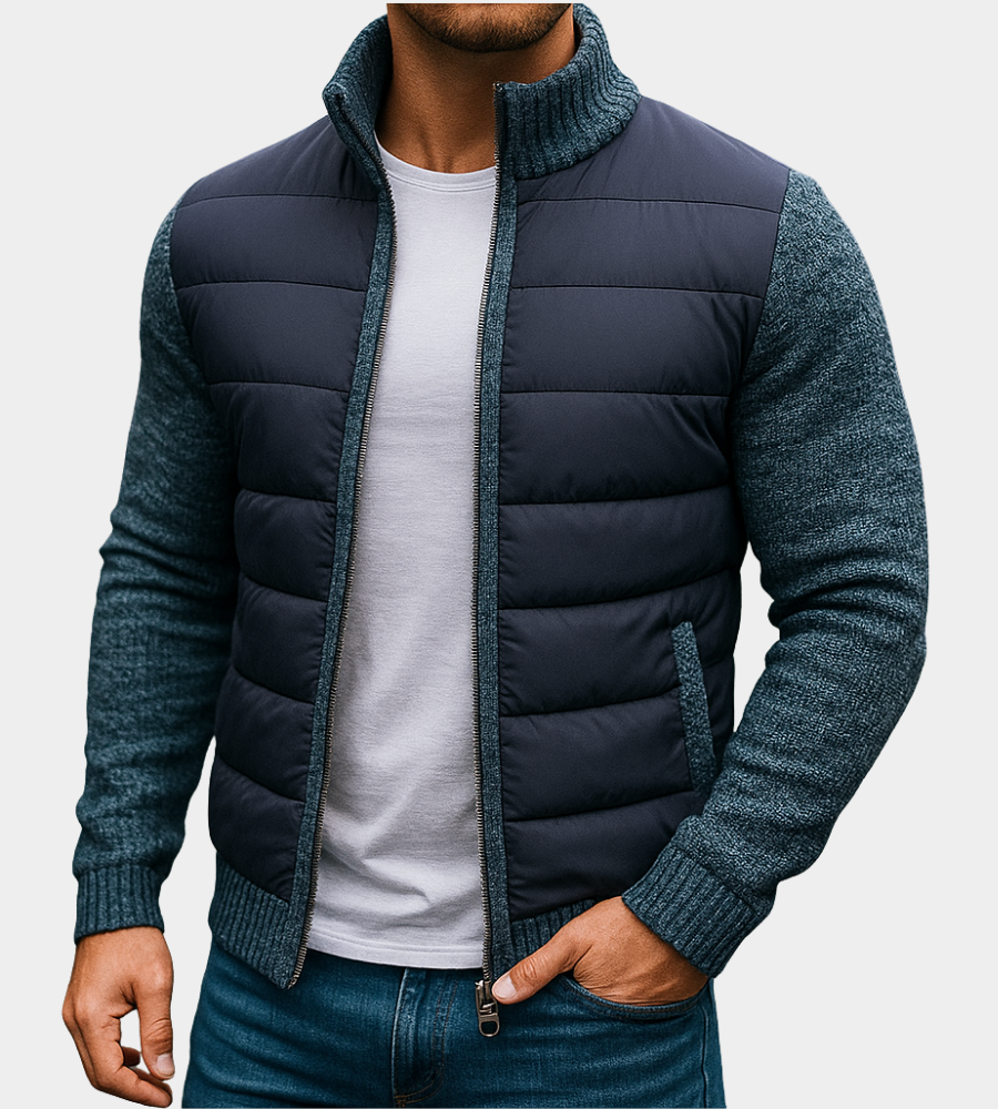 Navy quilted jacket with blue-gray knit sleeves and collar, worn open over a white tee with one hand in a jeans pocket. 4
