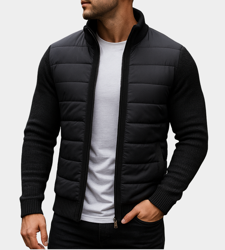 All-black quilted jacket with knit sleeves and ribbed cuffs, worn unzipped over a white tee, one hand in pocket. 5