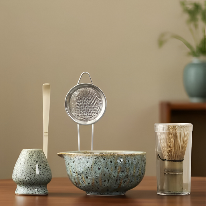 Blue-green speckled glazed matcha set with whisk holder, steel sifter, bamboo scoop and bamboo whisk in a clear tube.
