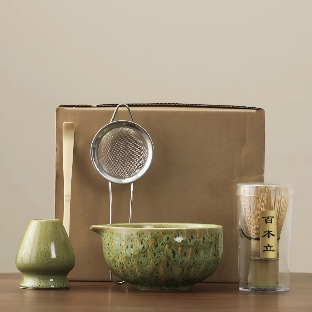 Another view of an olive-green glazed ceramic matcha set with whisk holder, sifter, bamboo scoop and whisk in a clear tube.