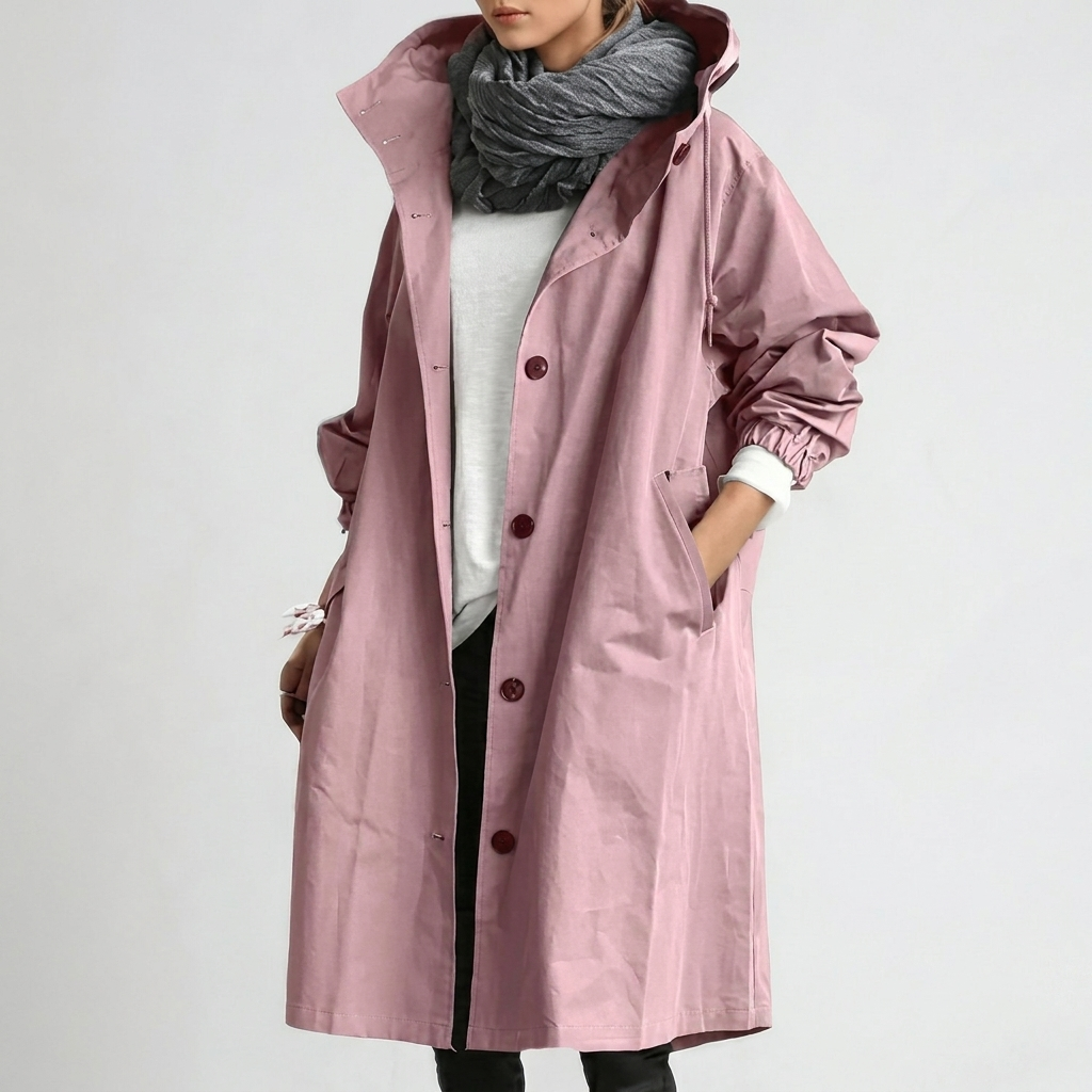 Women's Raincoat in dusty pink with hood and button front, shown on a model with one hand in a side pocket.