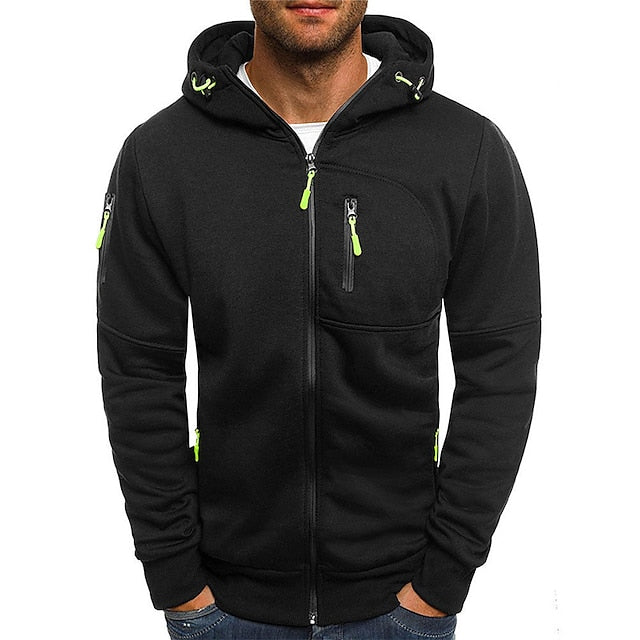 Men's black zip-up hoodie with lime green zipper pulls, a chest zip pocket, a sleeve zipper, and hands in jeans pockets.