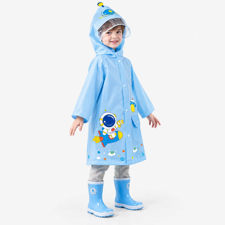 Boy in a light blue raincoat with an astronaut and rocket print, clear hood visor, and blue rain boots, turned slightly sideways. 5