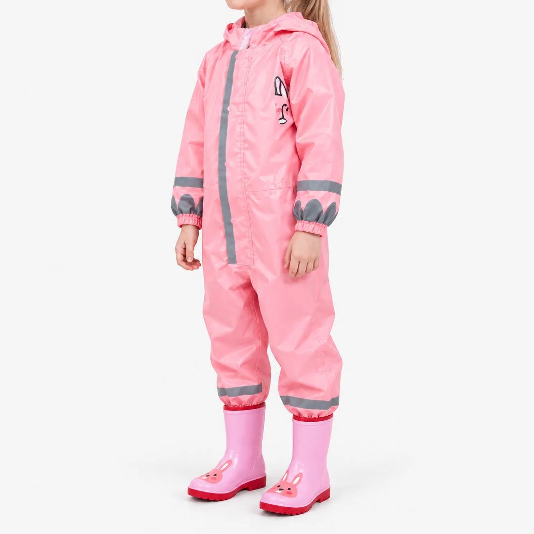 Side view of a child in the pink jumpsuit with a bunny design on the chest, reflective stripes and bunny rain boots. 5