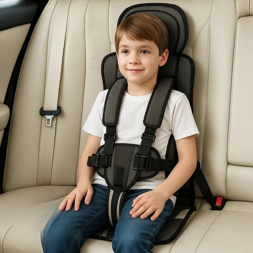 Dark gray foldable kids travel seat with shoulder pads and chest harness.