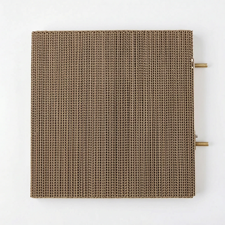 Top-down view of the square corrugated cardboard platform, with two threaded brass mounting bolts sticking out from one side. 5
