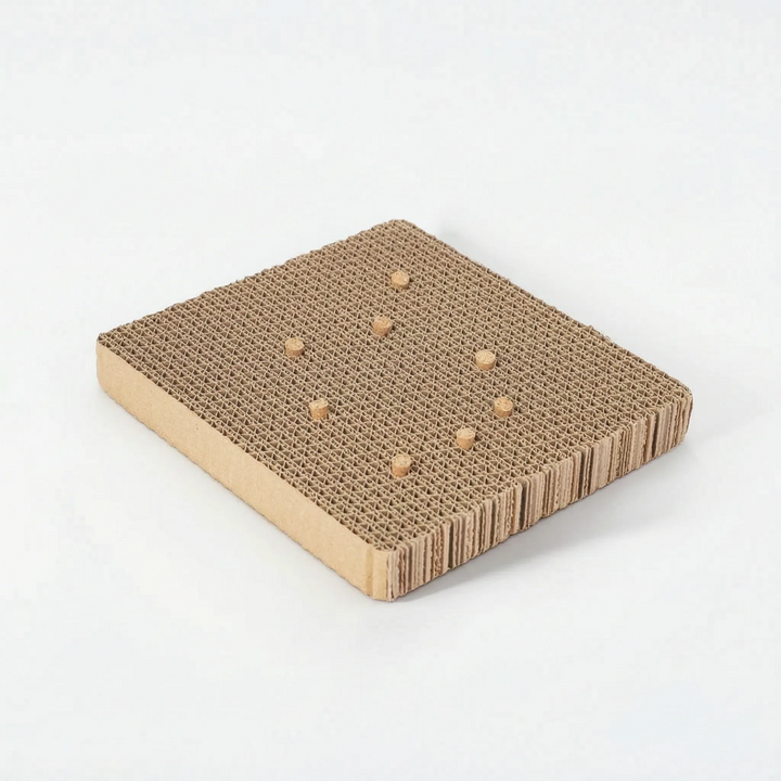 Corrugated cardboard platform with eight cork pieces set into the top, angled view on a white background. 6