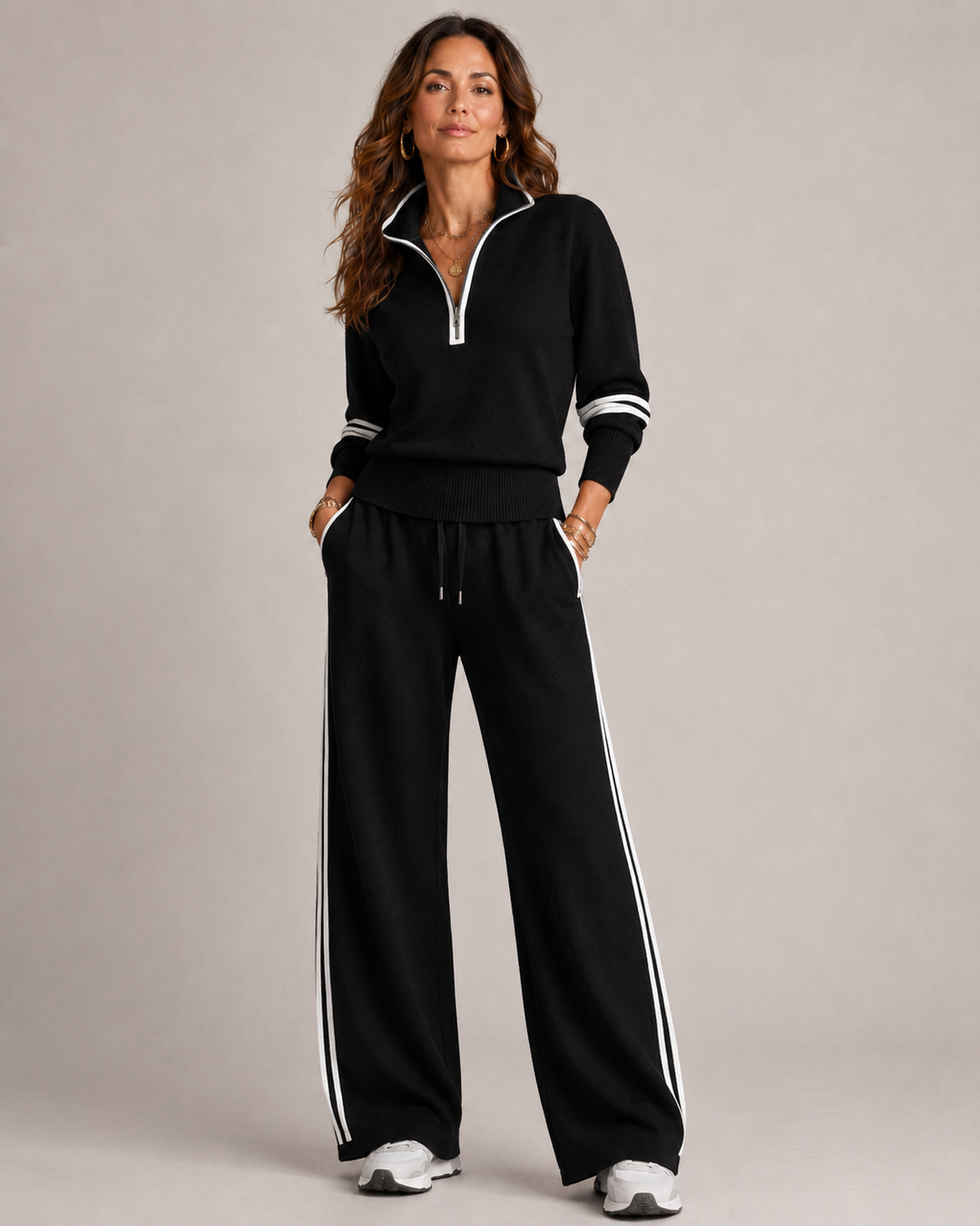 Woman standing with hands in pockets in the black set with white stripe trim on the sleeves and pants. 5