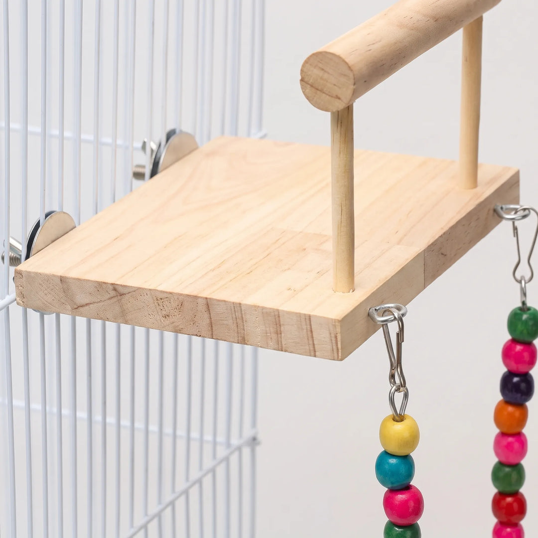 Close-up of the pine platform's grain, perch rail, metal clips and cage-mounting washers, with colorful wooden beads hanging below. 3