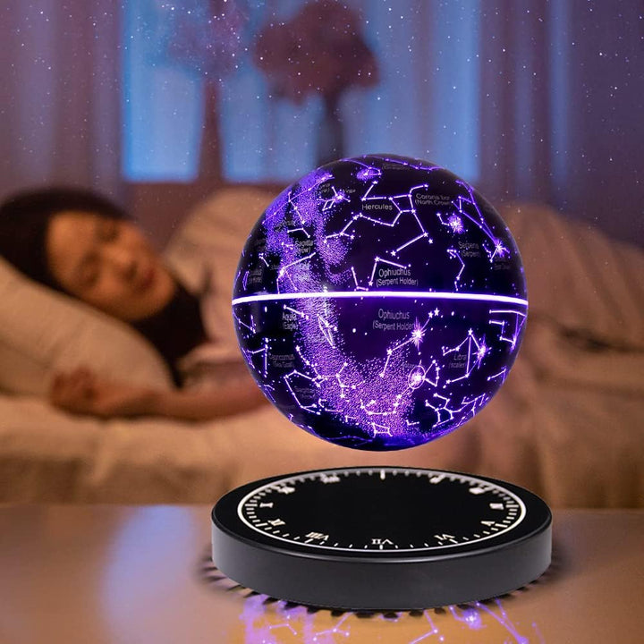 Purple glowing floating globe on a bedside table with a blurred woman lying in bed in the background.