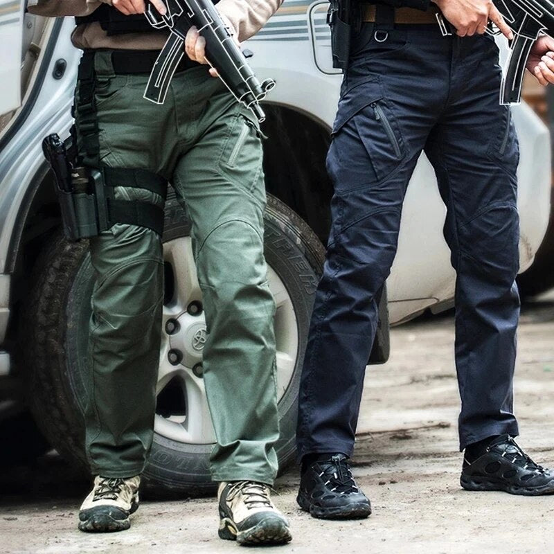Men's cargo pants in green and blue on two men beside an SUV, showing the knee panels and zip pockets.