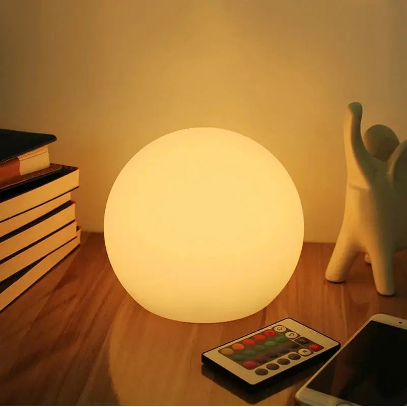 White orb lamp with remote control on a wooden desk