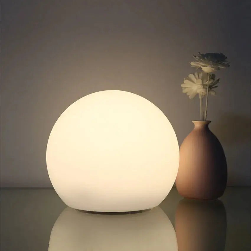 White orb lamp detail on a reflective surface