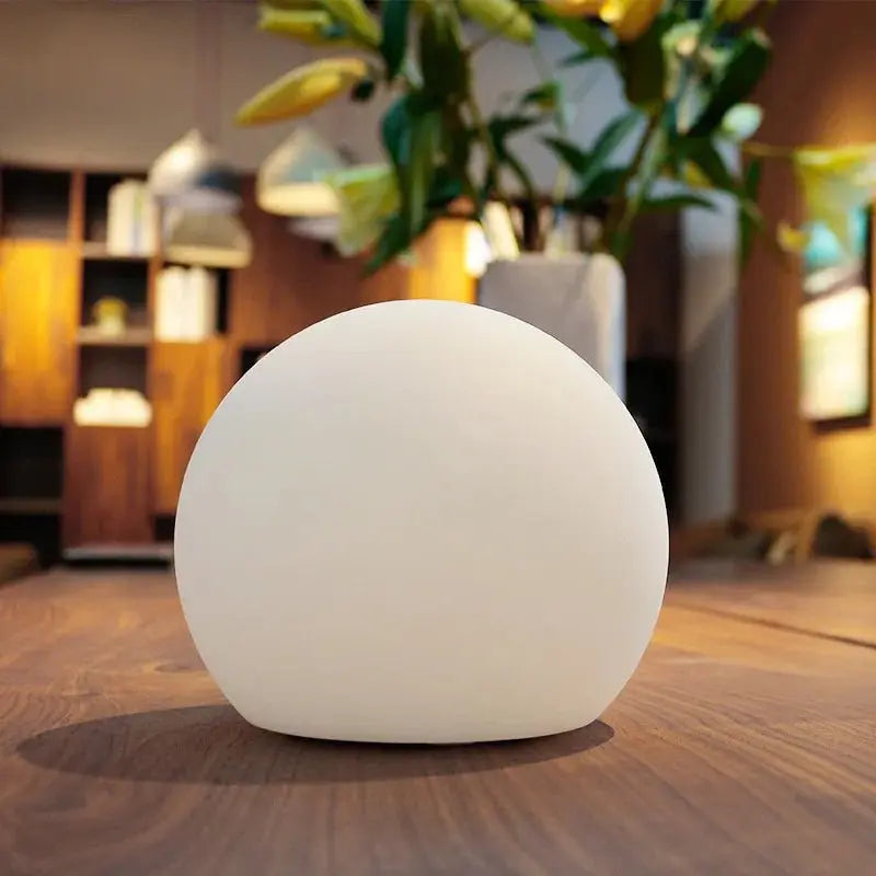 Unlit white orb lamp on a wooden table