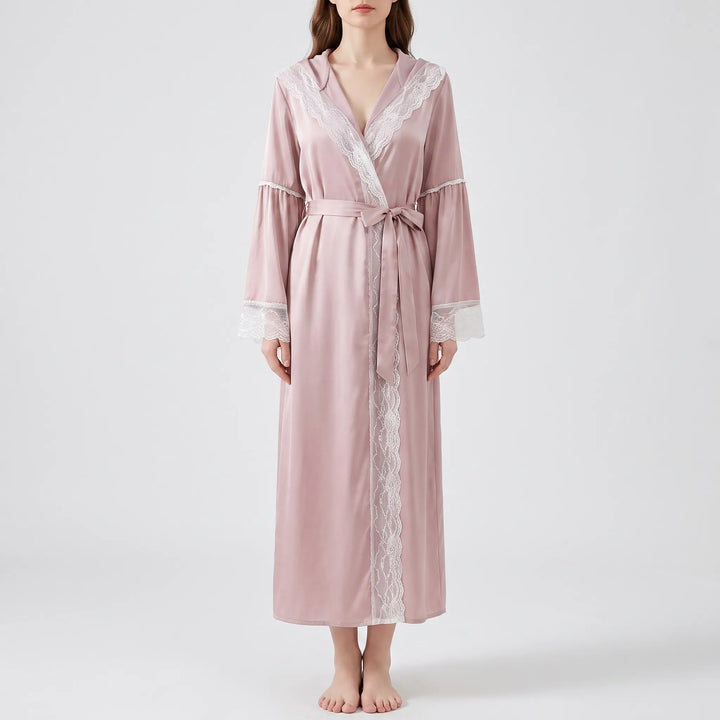 Front view of a model in the long pink satin robe tied with a bow sash, with white lace down the front opening. 6