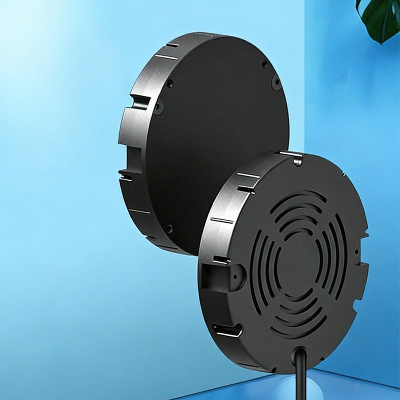 Two black round chargers, one showing its flat face and the other its slotted vent side with cable.
