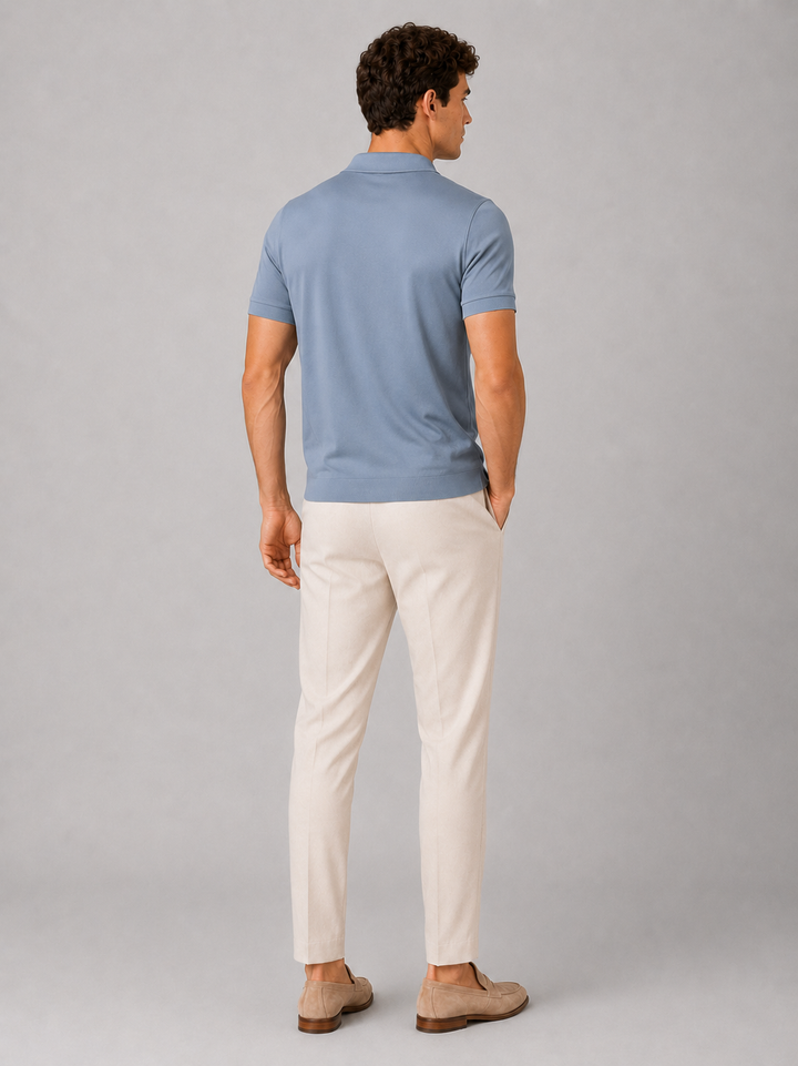 Dusty blue silky touch polo shirt back view on a model.