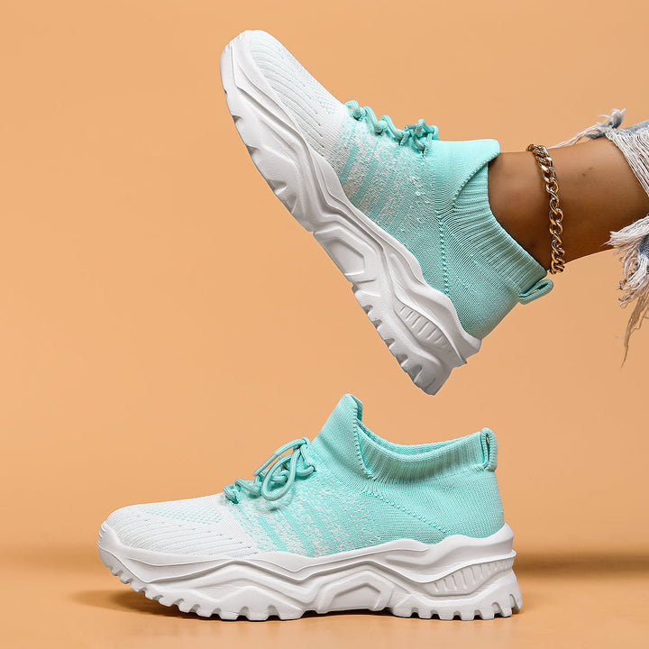 Mint green and white knit sock sneakers, side view with the thick sole visible.