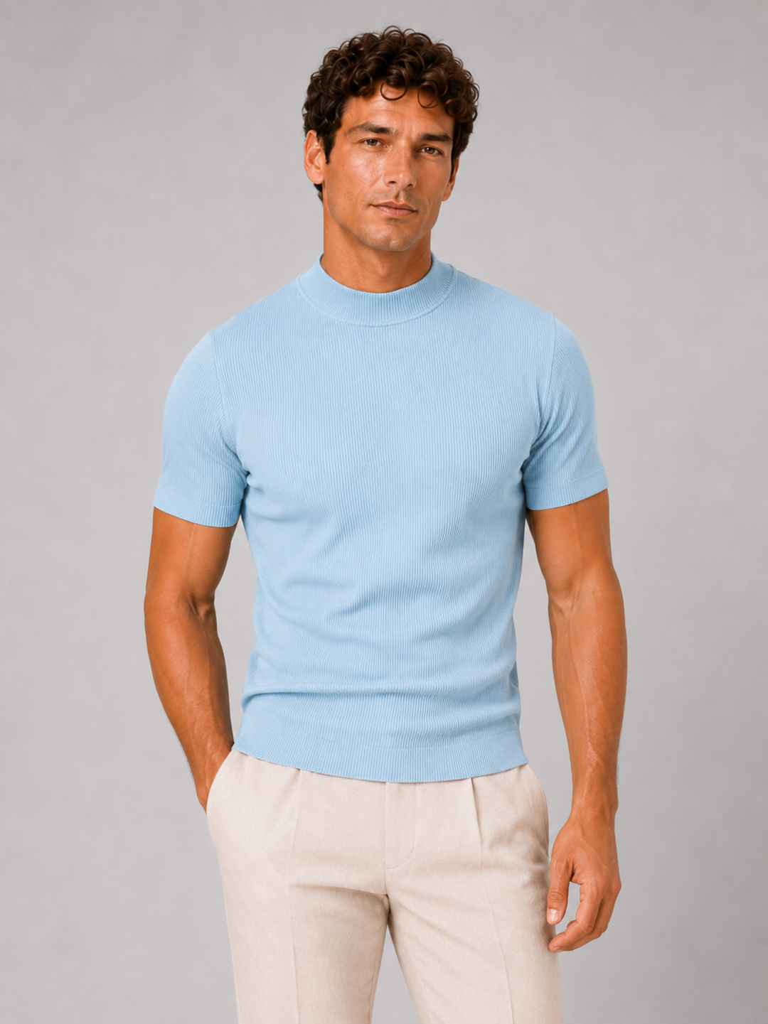 Front view of a men's light blue ribbed mock neck tee with cream trousers, hand in pocket.