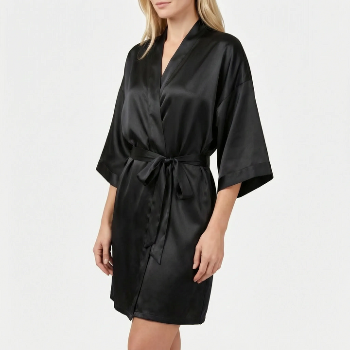 Model wearing the robe in black satin with a tied belt, wrap front and wide three-quarter sleeves. 15