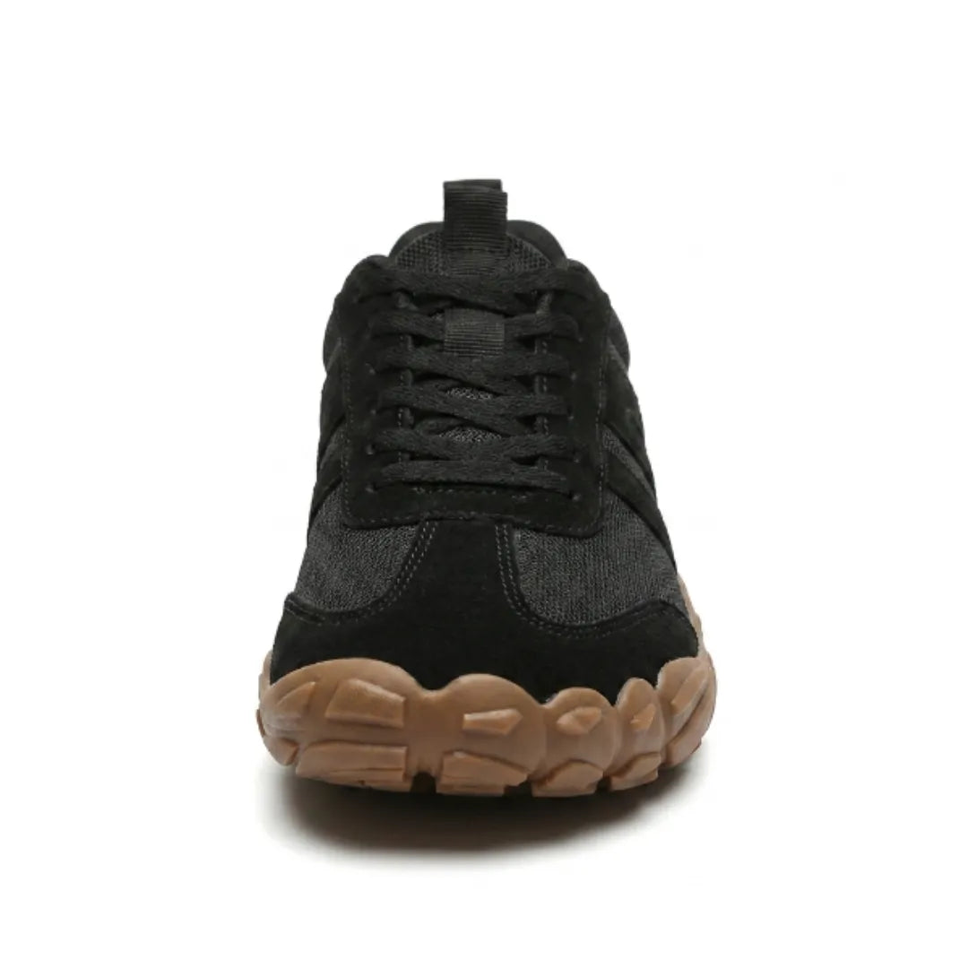 Front view of the black lace-up sneaker showing the broad rounded toe, laces and chunky tan gum sole. 26