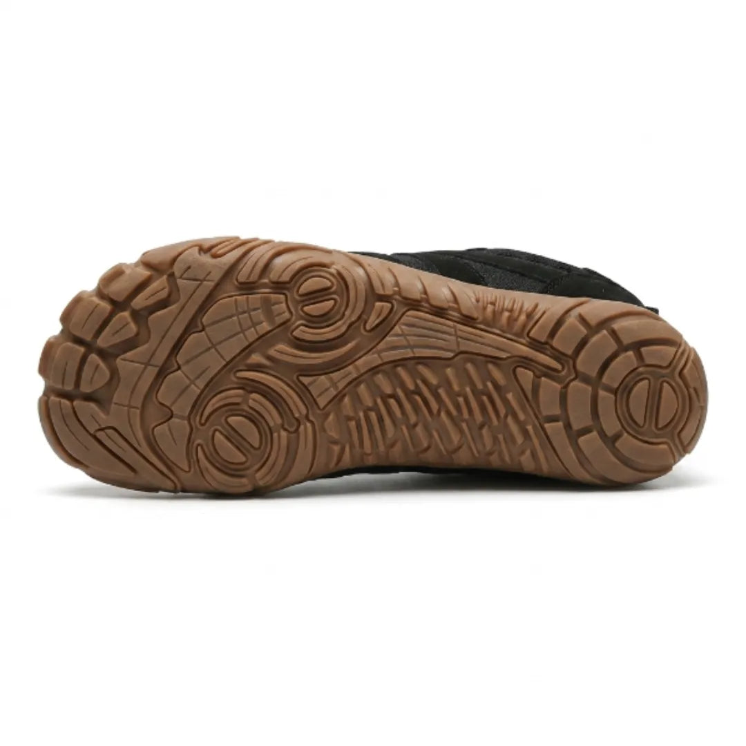 Underside of the black shoe showing the tan gum outsole with a detailed grip tread pattern and flex zones. 27