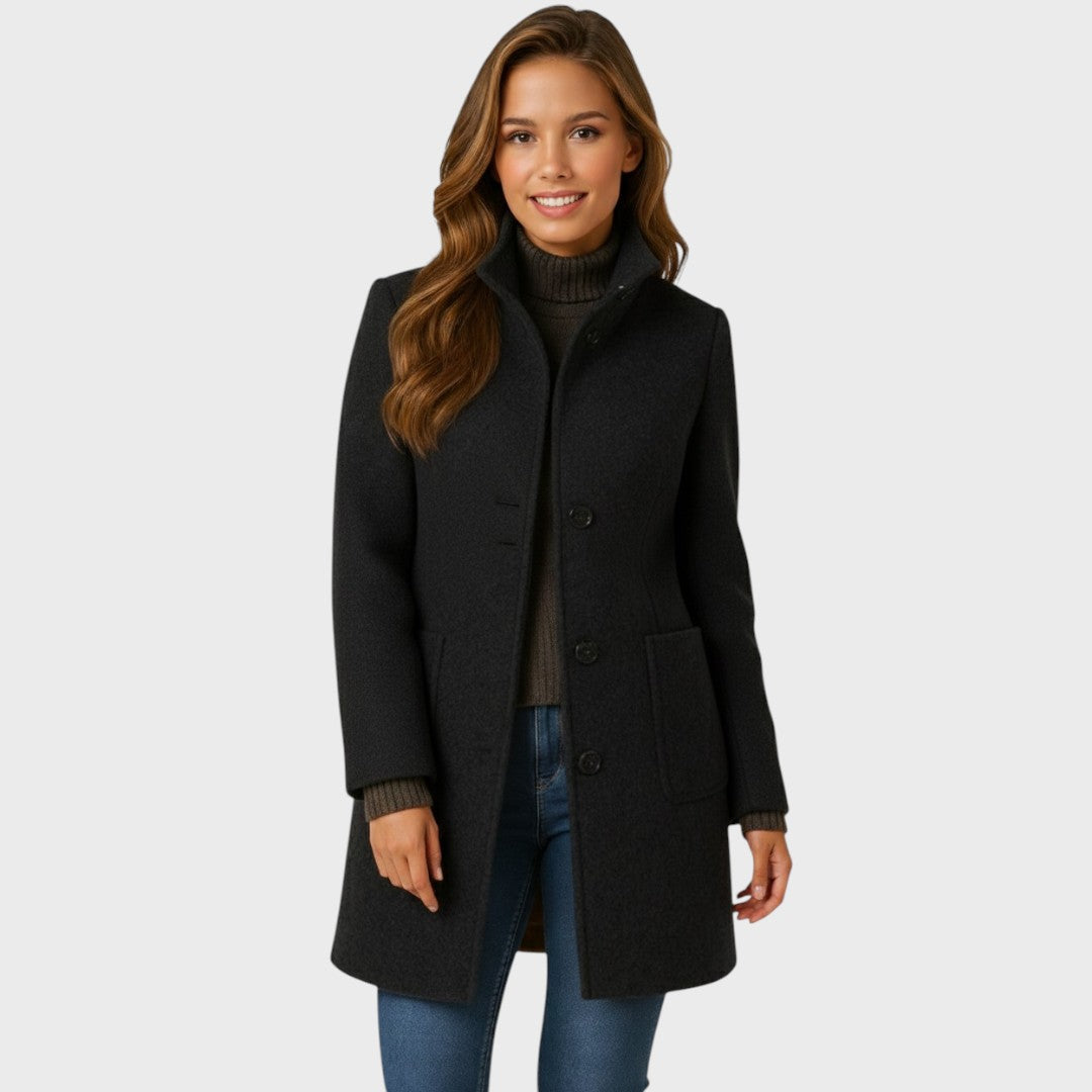 Smiling model in the black version of the coat, worn open over a brown turtleneck and jeans, with patch pockets visible. 3
