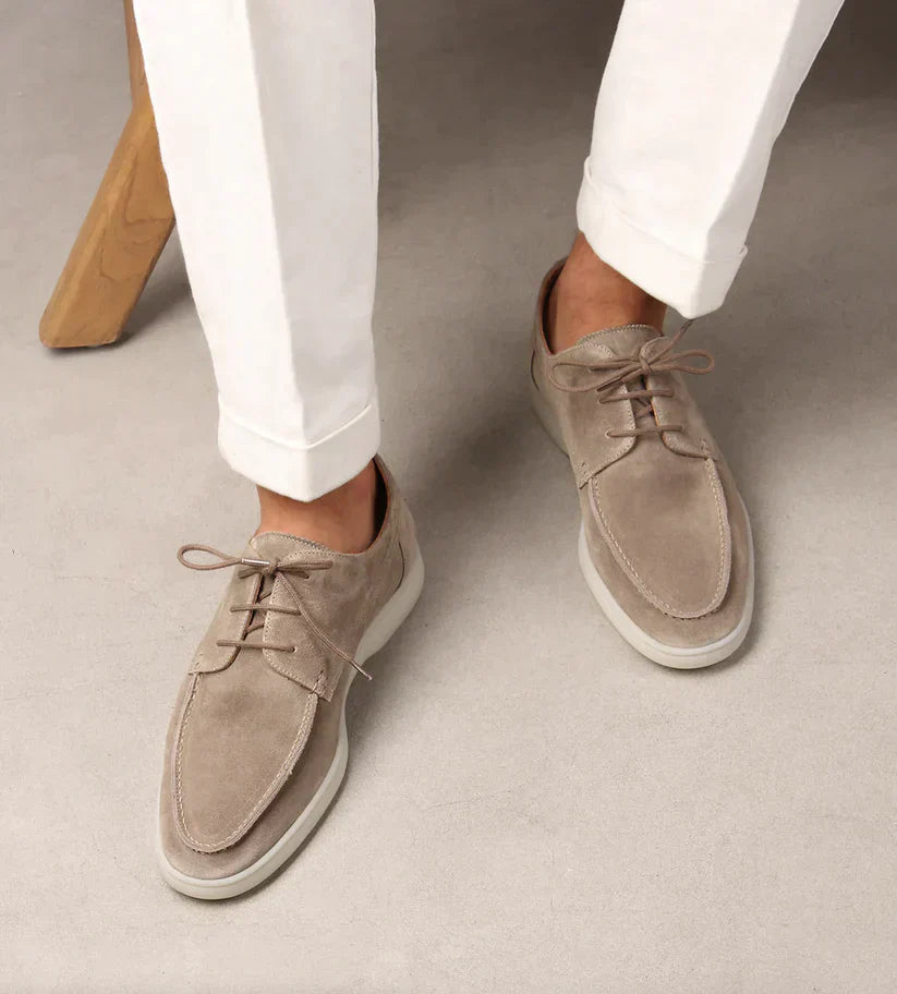 Men's blue leather lace-up shoes, another view with cuffed white trousers.