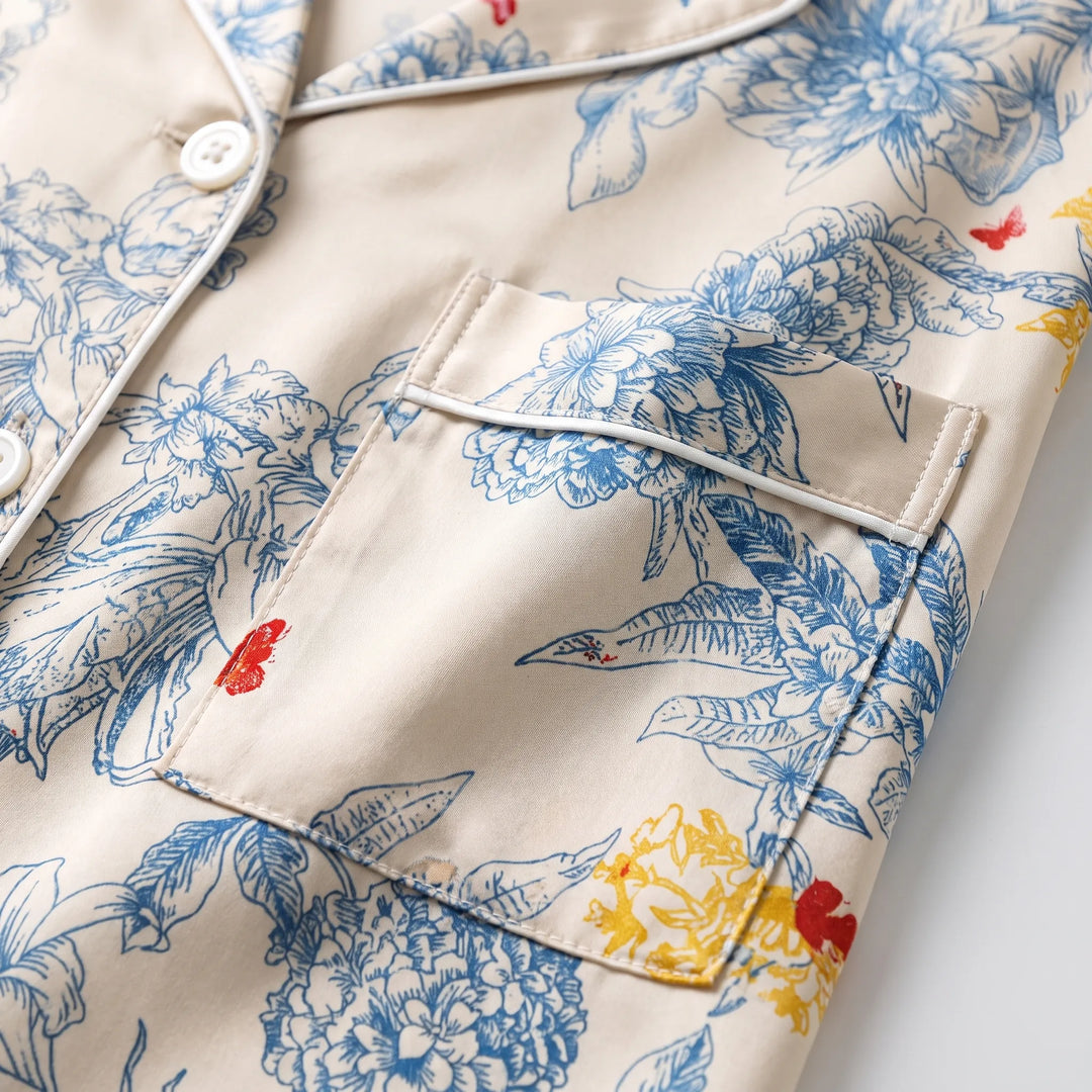 Close-up of the chest pocket, white piping, buttons and blue floral print with yellow and red accents on cream fabric. 5