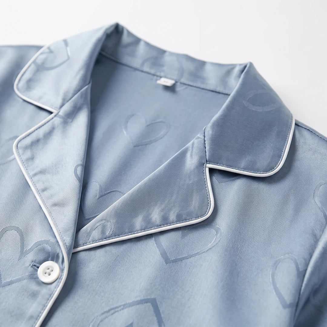 Close-up of the blue satin collar with white piping, a pearly button and the tonal heart jacquard weave. 5