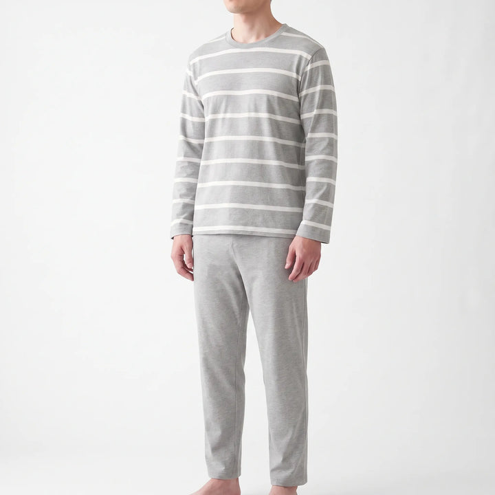 Three-quarter front view of a model wearing the striped gray top with matching plain gray pants against a white background. 2