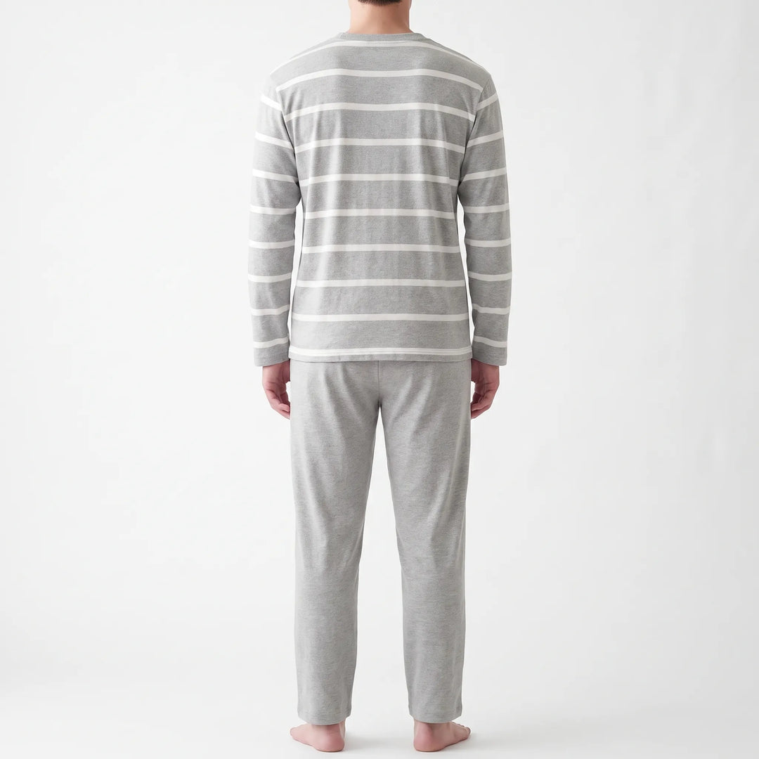 Back view of the model in the striped gray long-sleeved top and plain gray pants, shown from head to bare feet. 3