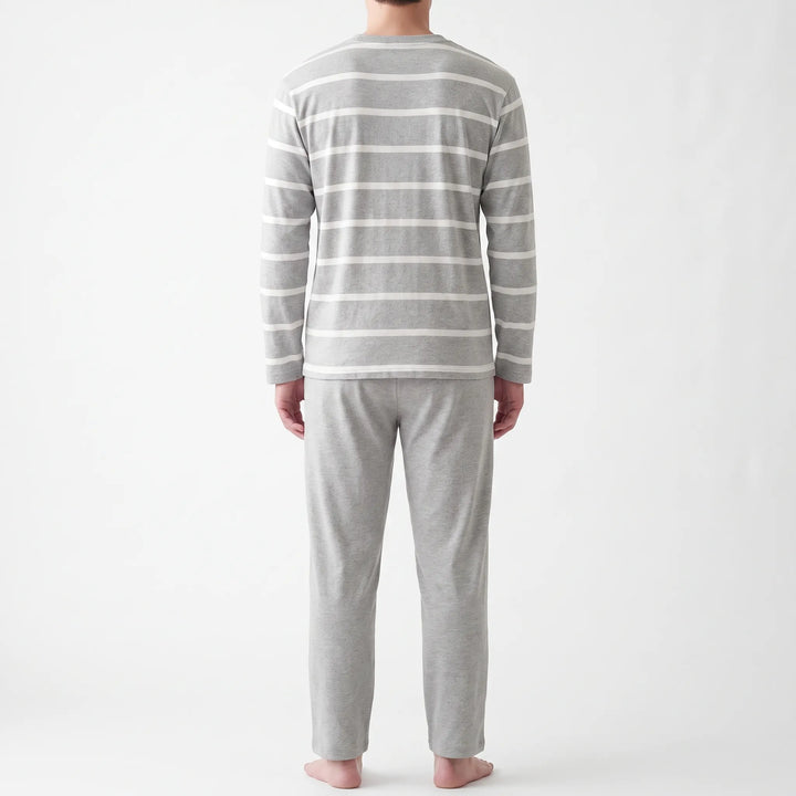 Back view of the model in the striped gray long-sleeved top and plain gray pants, shown from head to bare feet. 3