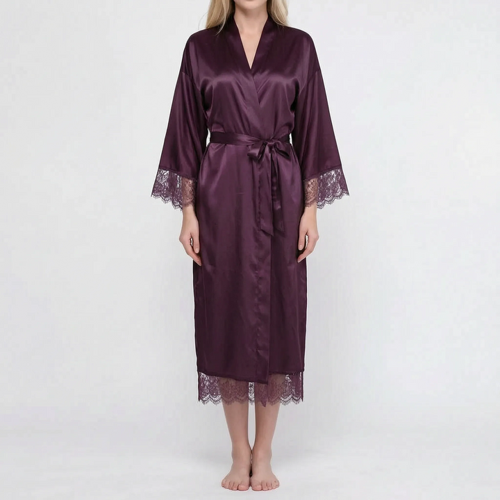 Model wearing the satin robe in dark plum purple with wide sleeves, plum lace cuffs and hem, and a tied belt. 12