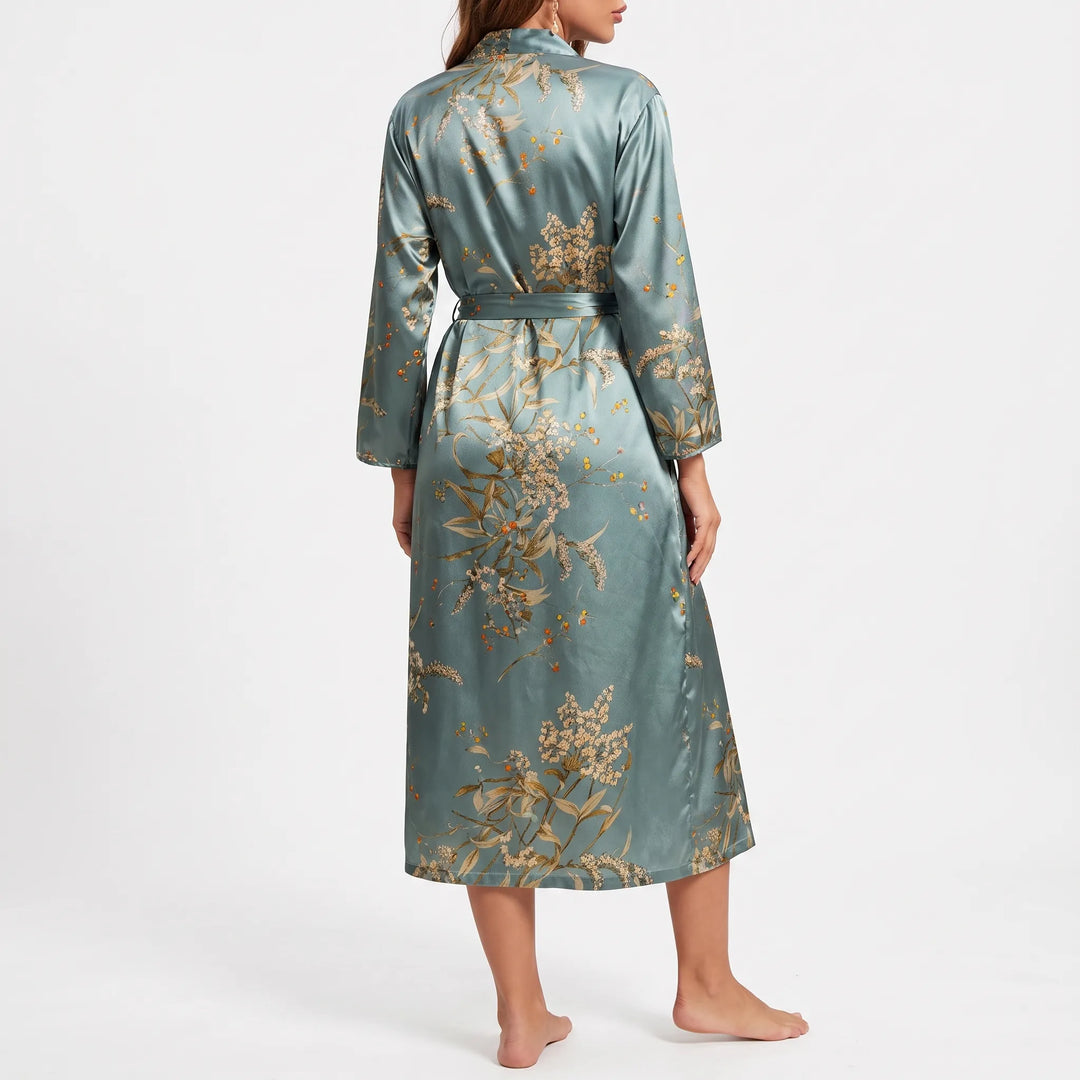 Back view of the blue-green satin robe on a barefoot model, showing the large floral print across the back and sleeves. 3