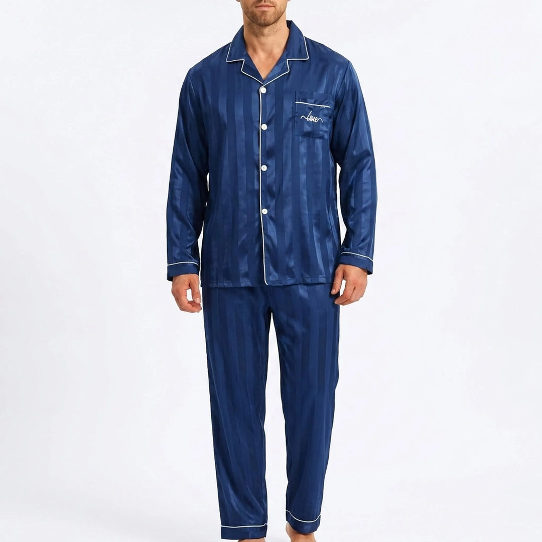 Front view of a model wearing the navy striped satin pajamas with white piping, buttoned shirt and matching long pants. 2