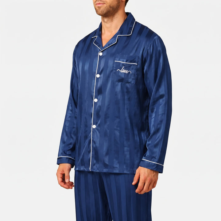 Three-quarter side view of the navy satin pajama shirt, showing white buttons, piped chest pocket with embroidery and long sleeves. 4