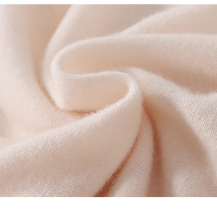 Extreme close-up of soft, fuzzy cream knit fabric folded in a gentle swirl 5
