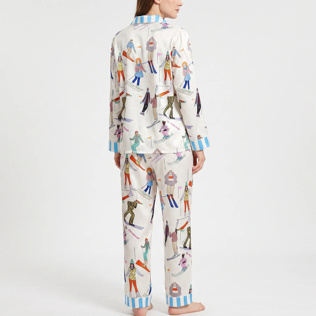 Back view of the pajama set on a model, showing the skier print across the shirt and pants with blue striped cuffs. 3